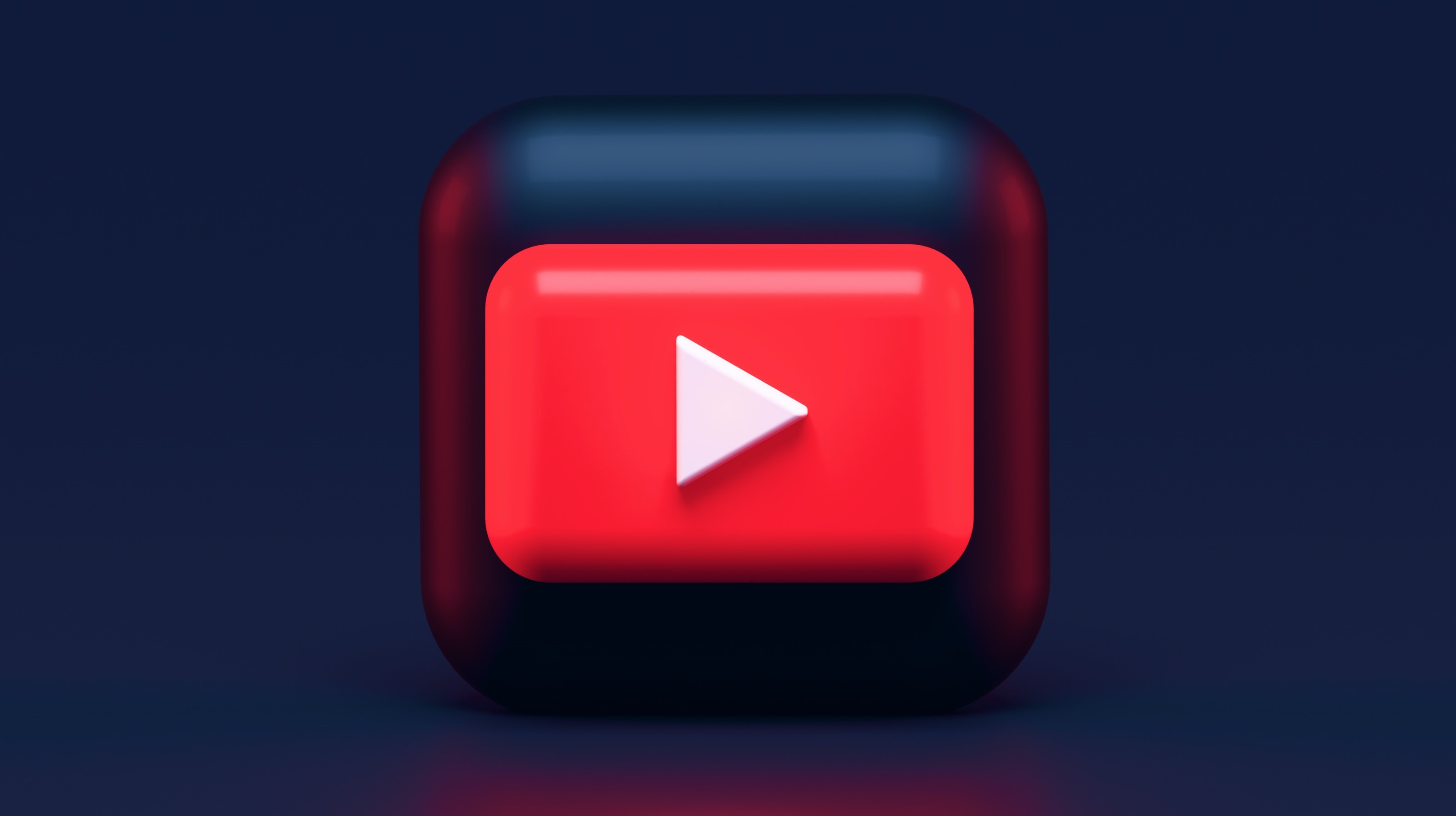 Logotipo de YouTube en 3D con fondo azul oscuro y base trasera negra también en 3D.